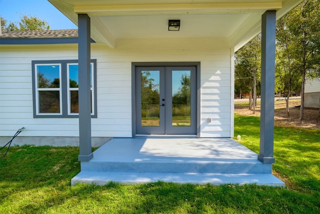 entrance to property featuring a yard and french doors