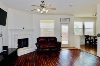 living room featuring wood-type flooring and ceiling fan