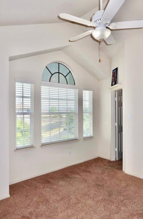 unfurnished room with vaulted ceiling, carpet floors, and ceiling fan