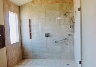 bathroom featuring a healthy amount of sunlight and a shower with shower door