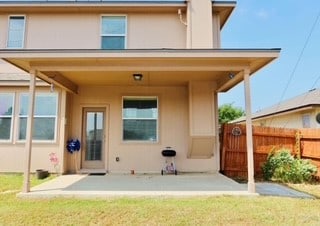 back of property featuring a patio and a lawn