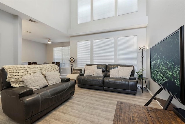 living room with a high ceiling and light wood-type flooring