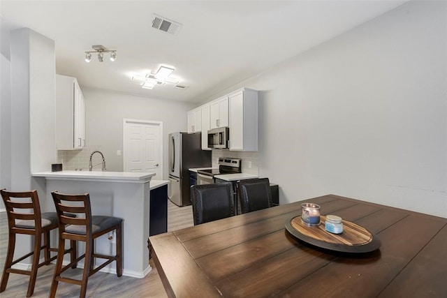 dining room with sink and light wood-type flooring