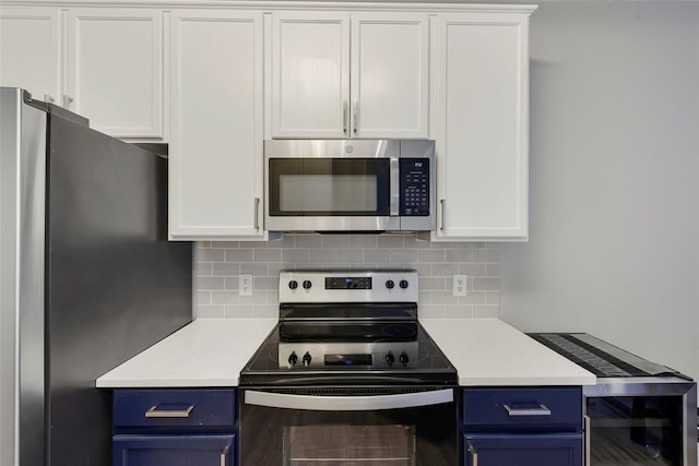 kitchen with white cabinetry, blue cabinetry, and stainless steel appliances