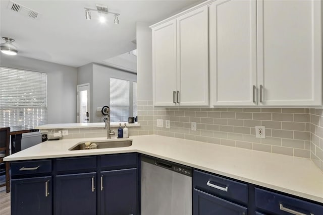 kitchen with sink, dishwasher, a wealth of natural light, and white cabinets