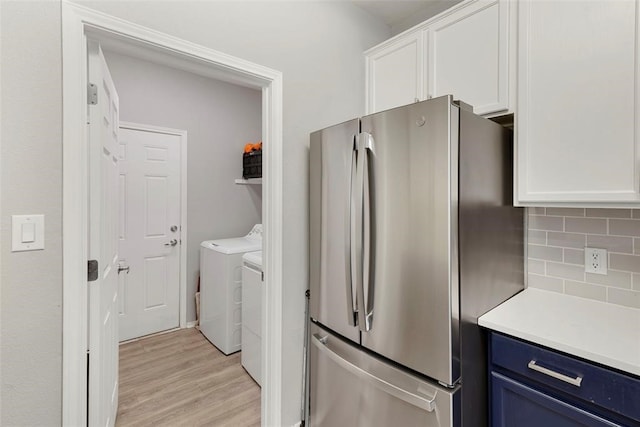 clothes washing area featuring independent washer and dryer and light wood-type flooring