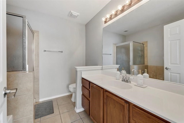 bathroom featuring vanity, tile patterned floors, toilet, and walk in shower