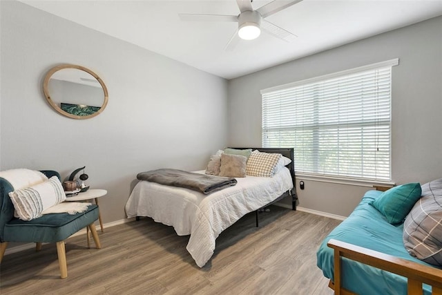 bedroom featuring hardwood / wood-style floors, multiple windows, and ceiling fan