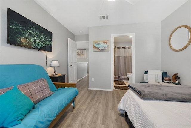 bedroom with light hardwood / wood-style floors, ensuite bath, and ceiling fan