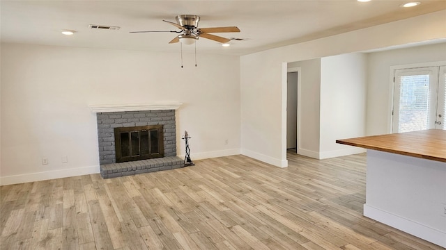 unfurnished living room with light hardwood / wood-style floors, a fireplace, and ceiling fan