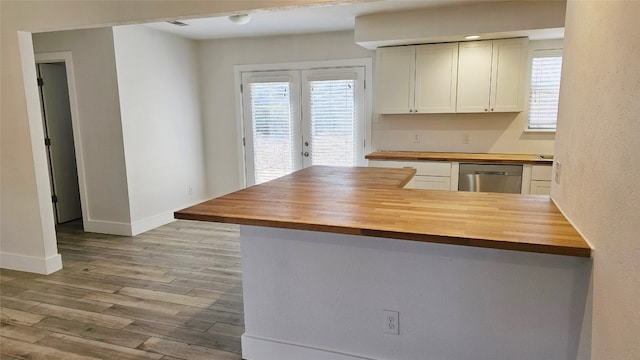 kitchen featuring dishwasher, butcher block counters, kitchen peninsula, and light wood-type flooring