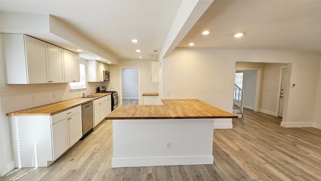 kitchen featuring sink, white cabinetry, stainless steel appliances, wooden counters, and light hardwood / wood-style flooring