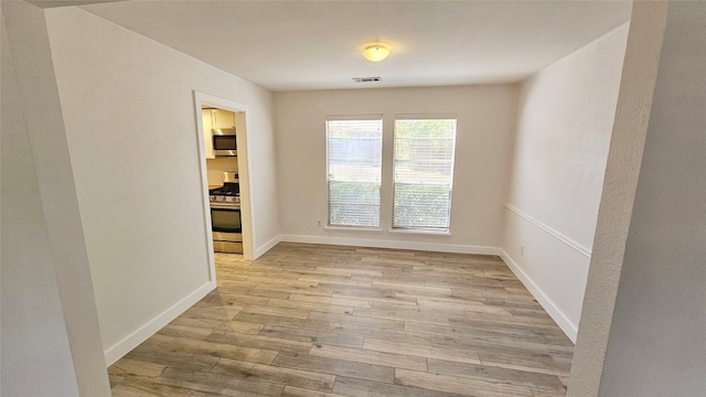 unfurnished room with light wood-type flooring