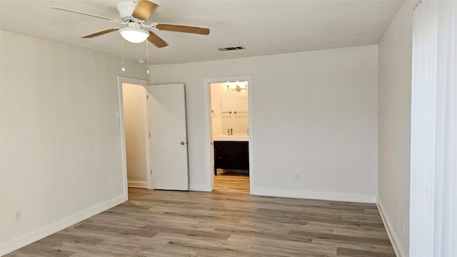 unfurnished bedroom featuring ensuite bathroom, light hardwood / wood-style floors, and ceiling fan