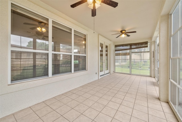 unfurnished sunroom featuring ceiling fan