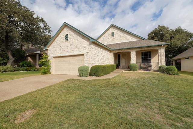 view of front of home with covered porch, a front yard, and a garage