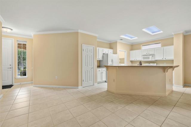 kitchen with white appliances, crown molding, a kitchen island with sink, and white cabinets