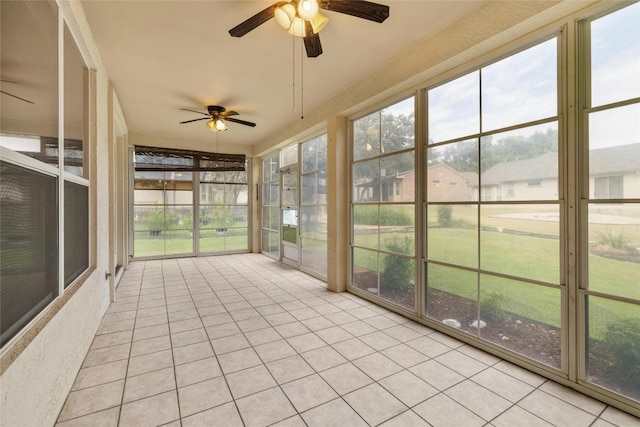 unfurnished sunroom featuring ceiling fan and a healthy amount of sunlight