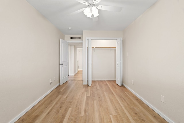 unfurnished bedroom with a closet, light wood-type flooring, and ceiling fan