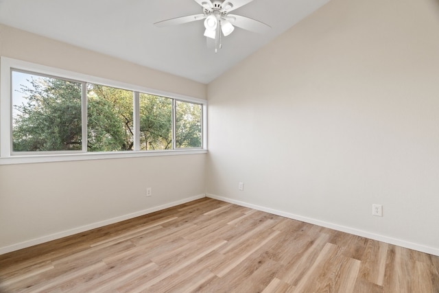 empty room featuring vaulted ceiling, ceiling fan, plenty of natural light, and light wood-type flooring