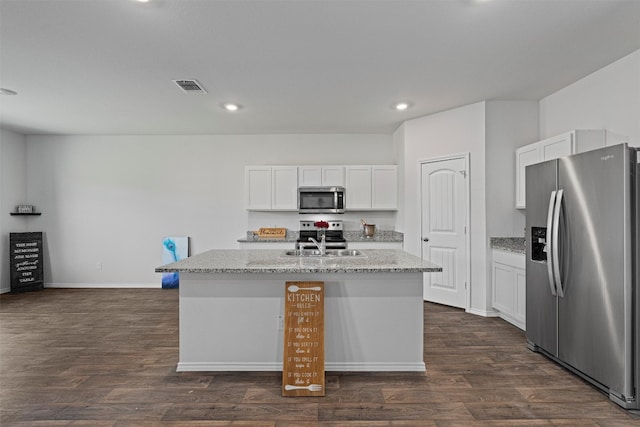 kitchen featuring light stone countertops, appliances with stainless steel finishes, a kitchen island with sink, and white cabinets