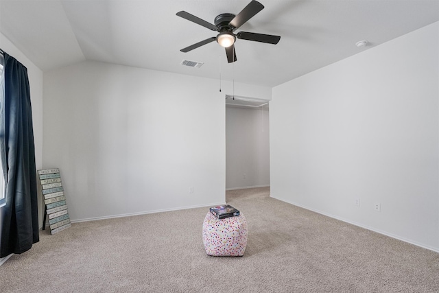 carpeted spare room with ceiling fan and vaulted ceiling