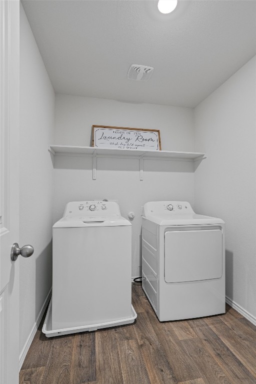 clothes washing area with washing machine and clothes dryer and dark hardwood / wood-style floors