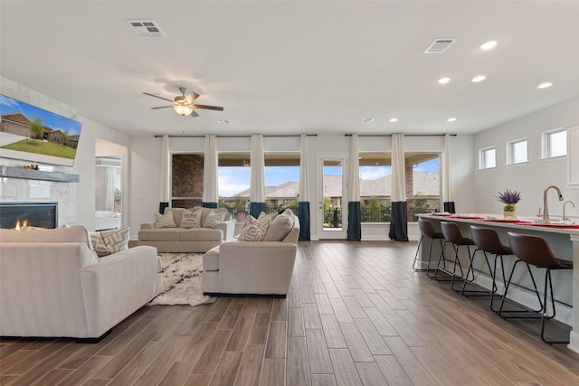 living room featuring sink, hardwood / wood-style flooring, ceiling fan, and plenty of natural light