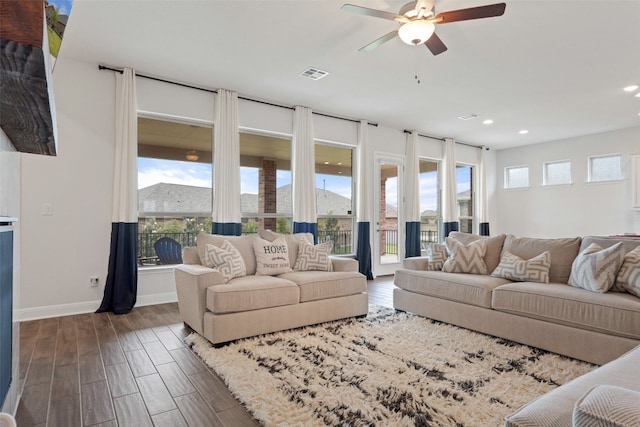 living room featuring dark wood-type flooring and ceiling fan