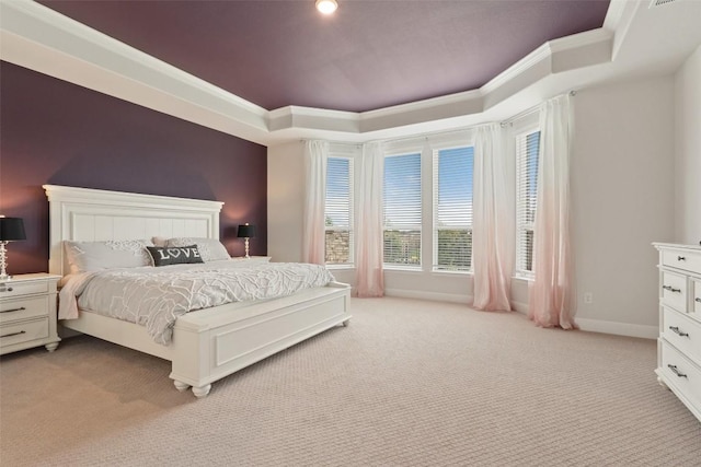 bedroom featuring light carpet, a tray ceiling, baseboards, ornamental molding, and visible vents