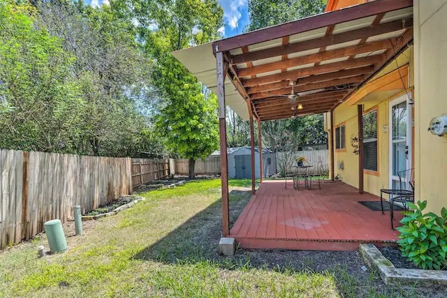 deck with a storage shed and a yard