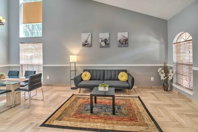 living area featuring high vaulted ceiling and light parquet flooring