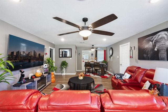 living room featuring wood-type flooring and ceiling fan