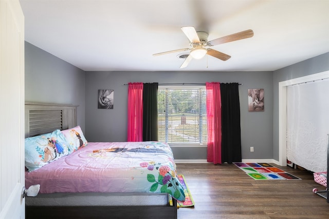 bedroom featuring a closet, dark wood-type flooring, and ceiling fan