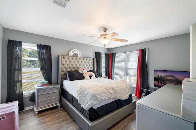 bedroom with dark hardwood / wood-style floors and ceiling fan