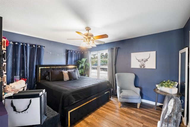 bedroom with ceiling fan, a textured ceiling, and hardwood / wood-style floors