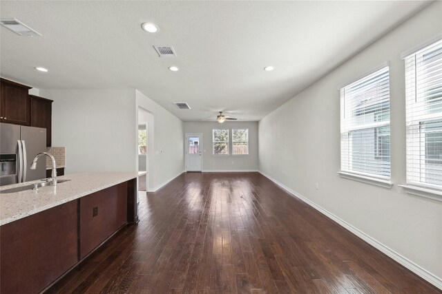 kitchen featuring dark wood-type flooring, stainless steel fridge with ice dispenser, dark brown cabinets, and ceiling fan