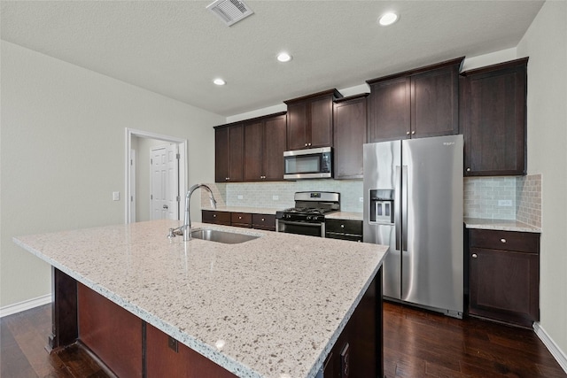 kitchen featuring sink, a kitchen island with sink, stainless steel appliances, and dark hardwood / wood-style flooring