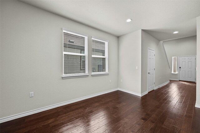 empty room with dark hardwood / wood-style flooring