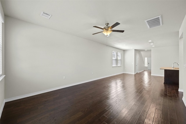 unfurnished living room with ceiling fan and dark hardwood / wood-style flooring