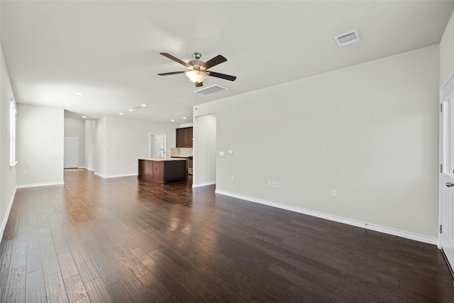 unfurnished living room with sink, ceiling fan, and dark hardwood / wood-style flooring