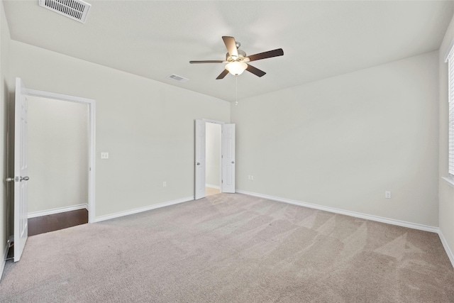 spare room featuring light colored carpet and ceiling fan