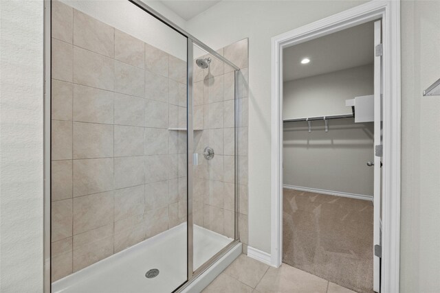 bathroom with walk in shower and tile patterned flooring