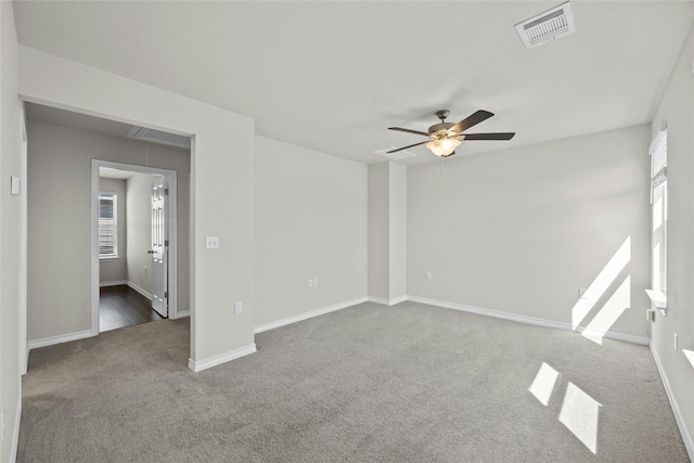 carpeted empty room with a wealth of natural light and ceiling fan