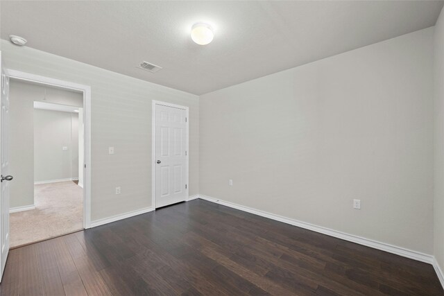 unfurnished bedroom with dark hardwood / wood-style floors and a closet