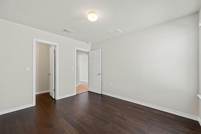 unfurnished bedroom with dark hardwood / wood-style flooring