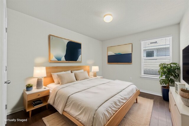 bedroom featuring dark wood-type flooring and a textured ceiling