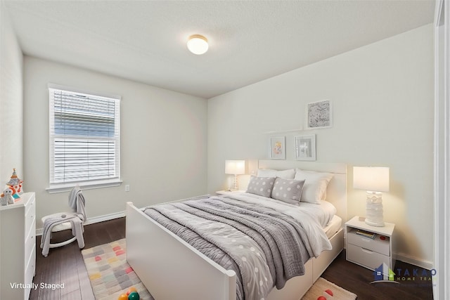 bedroom featuring dark wood-type flooring and a textured ceiling