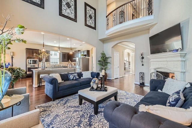 living room with dark hardwood / wood-style flooring and a towering ceiling