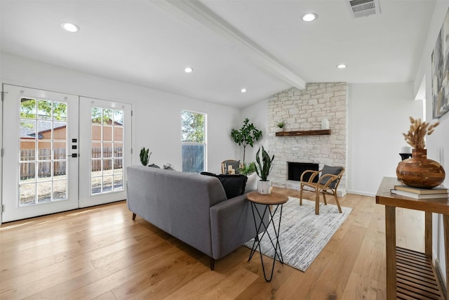 living room with french doors, lofted ceiling with beams, a fireplace, and light wood-type flooring